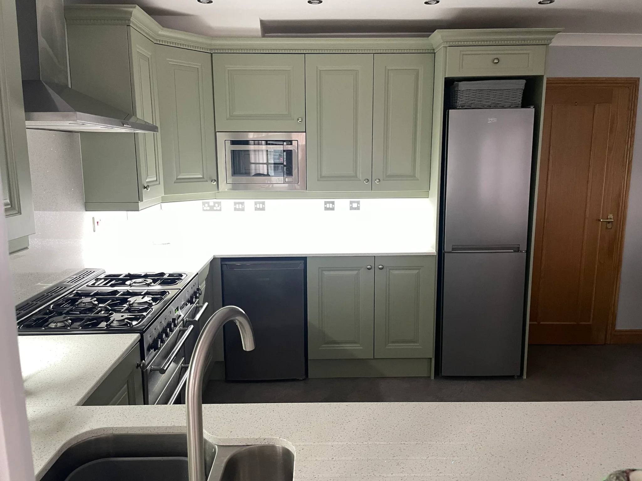 Detail of the completed kitchen — quartz worktops, range cooker and full-height cabinetry